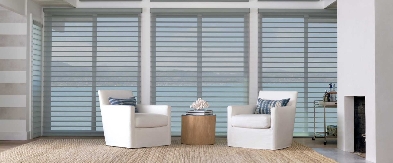 Two chairs in coastal themed room overlooking ocean.